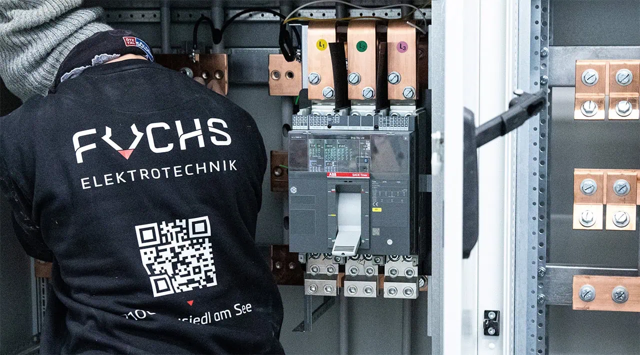 Ein Elektriker der Firma Fuchs verkabelt Schaltschrank