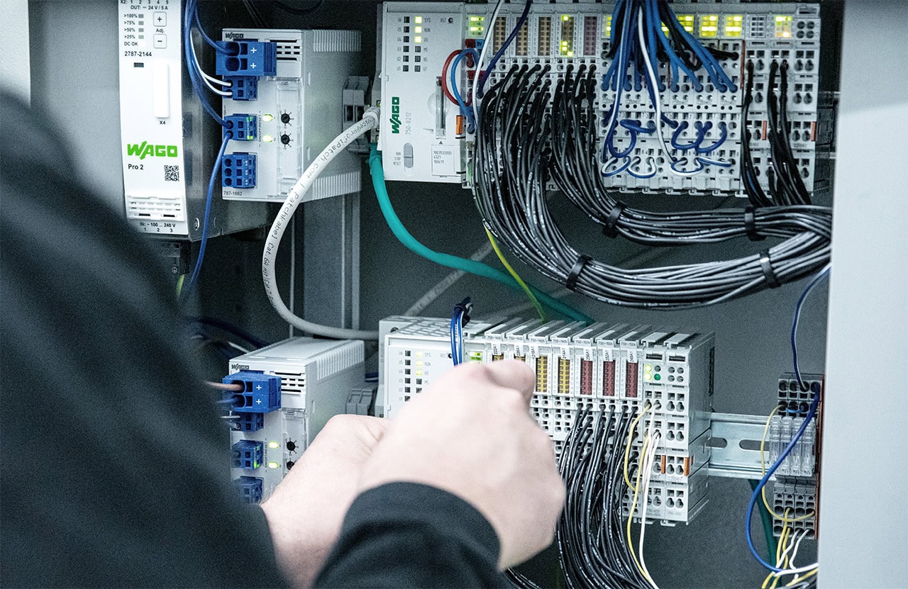 Fuchs Elektriker verkabelt Steuerung im Schaltschrank.