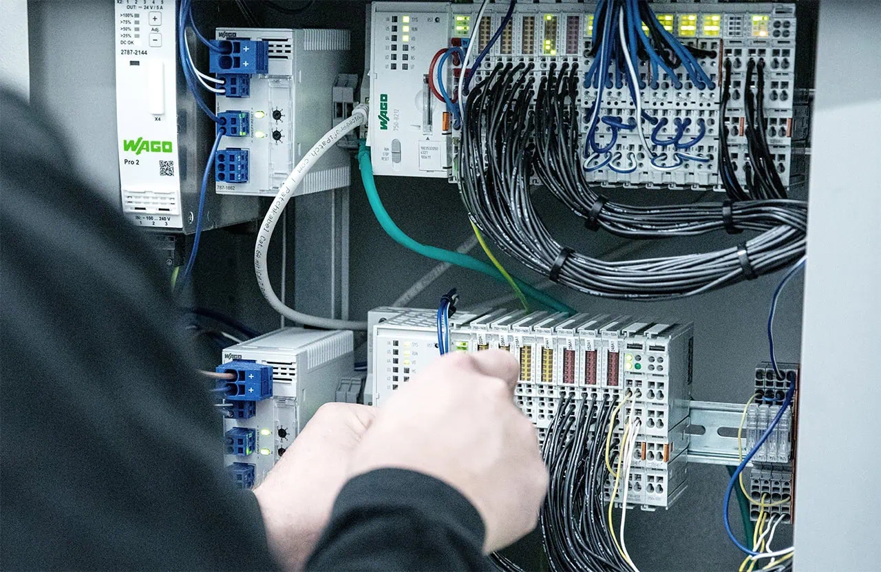 Fuchs Elektriker verkabelt Steuerung im Schaltschrank.