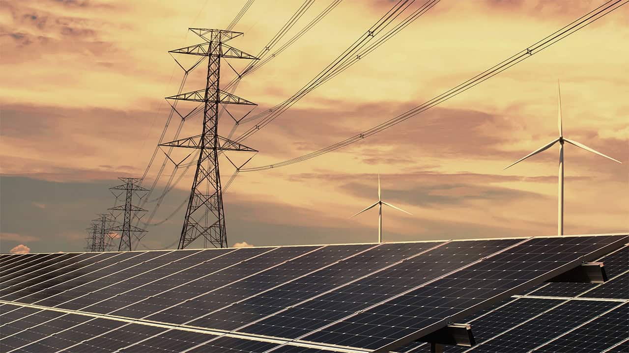 Solarpanele im Vordergrund im Hintergrund Strommasten und Stromleitungen