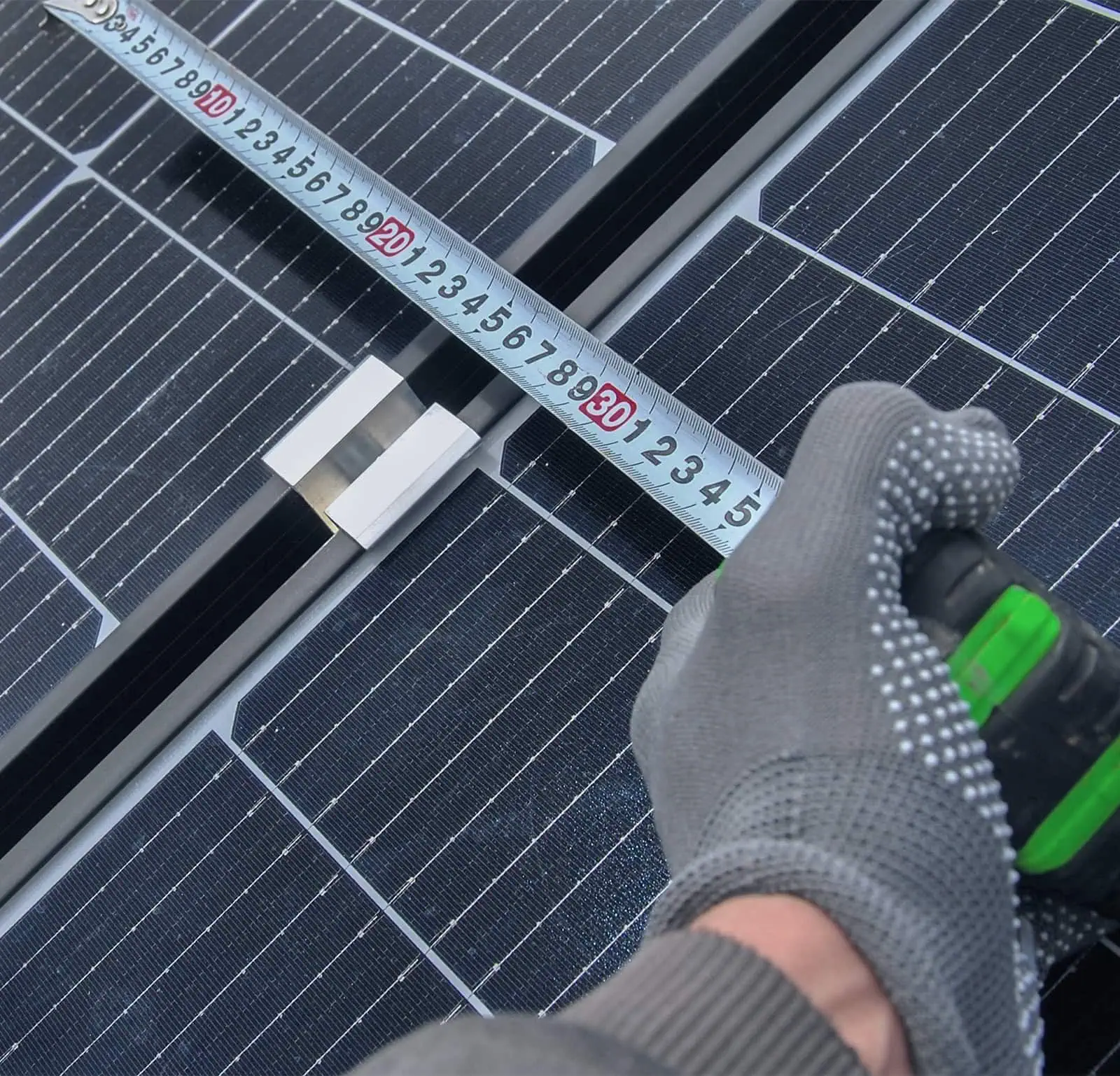 Fuchs Mitarneiter hält Massband an Photovoltaikmodul