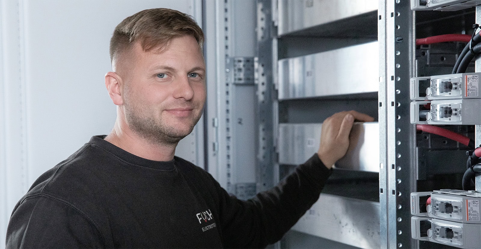 Geschäftsführer Sebastian Fuchs vor Rack mit Henry System