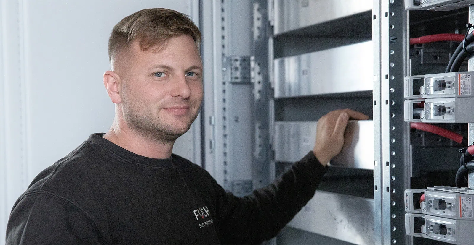 Geschäftsführer Sebastian Fuchs vor Rack mit Henry System
