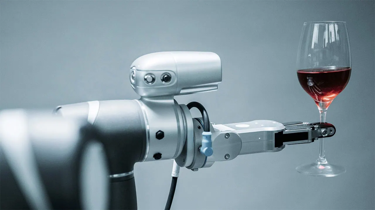Roboter hält Weinglas im Greifer.